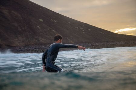 Surfer riding waves on the island of fuerteventura in the Atlantic Ocean, Canary Islandsの写真素材