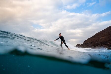 Surfer riding waves on the island of fuerteventura in the Atlantic Ocean, Canary Islandsの写真素材
