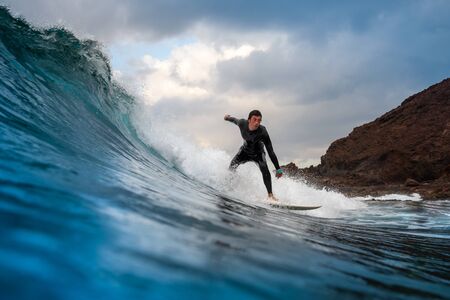 Surfer riding waves on the island of fuerteventura in the Atlantic Ocean, Canary Islandsの写真素材