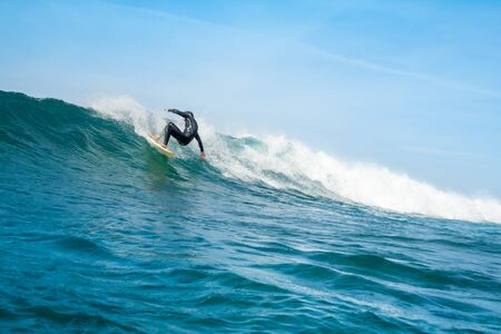 Surfer riding waves on the island of fuerteventura in the Atlantic Ocean, Canary Islandsの写真素材
