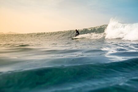 Surfer riding waves on the island of fuerteventura in the Atlantic Ocean, Canary Islandsの写真素材