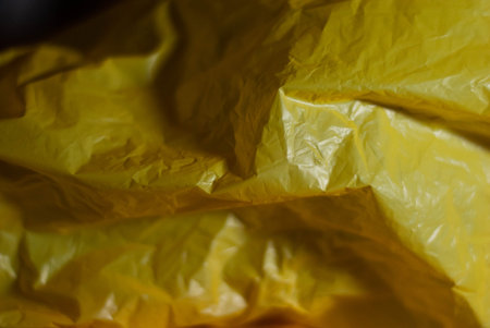 Wrinkled yellow plastic that causes different shades by contrasting the illuminated areas with the...