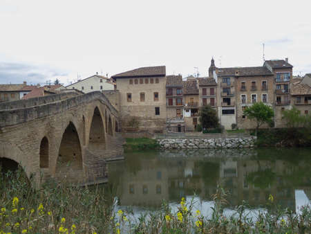 Bridge leading to a village located on the bank of a riverの写真素材