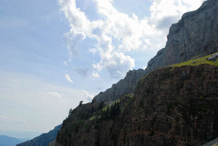 Mountainous landscape of long green mountain ranges with a clear blue sky with few clouds.の写真素材