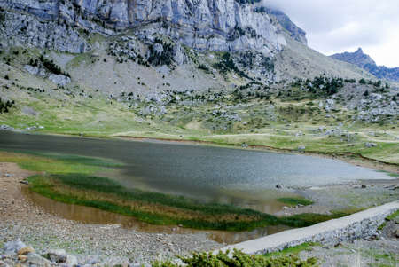 Lake surrounded by high mountains in a landscape full of mountains and natureの写真素材