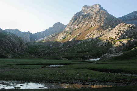 Lake surrounded by high mountains in a landscape full of mountains and natureの写真素材