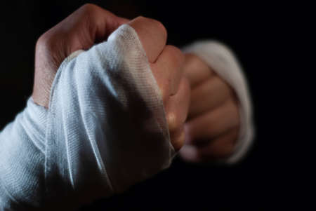 Hands of a boxer with white bandages prepared to fight in a sport battleの写真素材