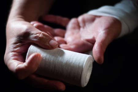 Hands of a boxer with white bandages prepared to fight in a sport battleの写真素材