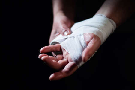 Hands of a boxer with white bandages prepared to fight in a sport battleの写真素材