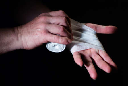 Hands of a boxer with white bandages prepared to fight in a sport battleの写真素材