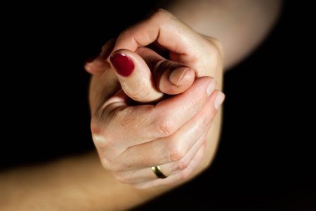 Hands of husband and wife lovingly holding hands while married for many yearsの写真素材