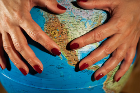 Hands of a woman holding a globe of the planet earth with marked places to travel on vacation