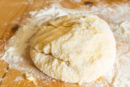 The dough made of flour and potatoes, on the plank  table.