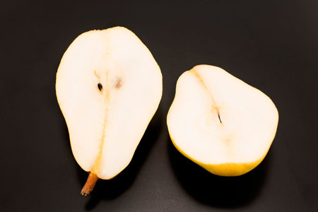 Two halves of a pear isolated on black.の写真素材