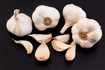 Bulbs and cloves garlic on a black background.