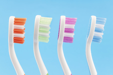 Colourful toothbrushes isolated on blue.の写真素材