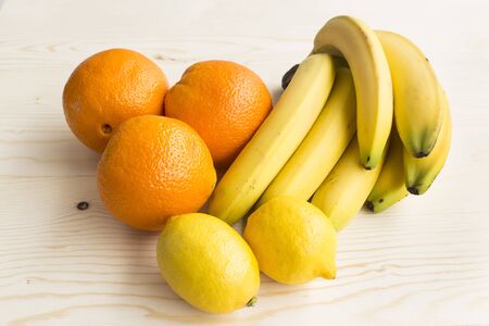 Tropical Fruits, Oranges, Bananas and Lemons on Wooden Background.の写真素材