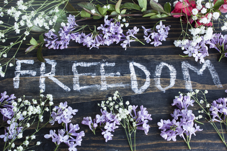 Word Freedom with Spring Flowers  on a Rustic Wooden Background.の写真素材