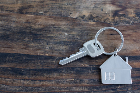 Key and House Pendant on a Rustic Wooden Background.の写真素材