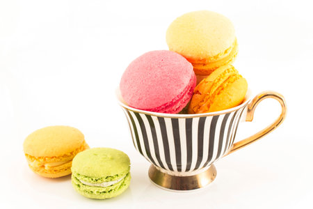 Colorful Macaroons in a Cup Isolated on White Background.の写真素材