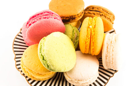 A Pile of Colorful Macaroons on a Plate on White Background.の写真素材