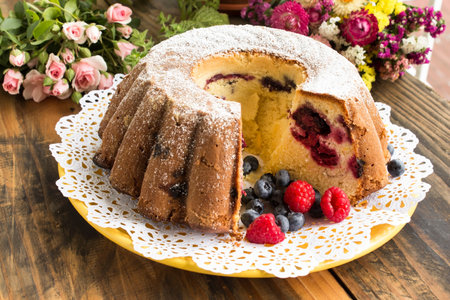 Kugelhopf with Berries on a Rustic Wooden Table.の写真素材