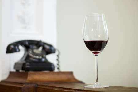 Glass os wine and old vintage clock on the background の写真素材