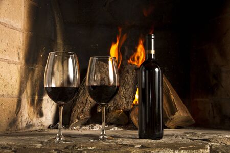 Wine by the fireplace, glasses of wine の写真素材