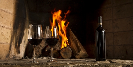 Wine by the fireplace, glasses of wine の写真素材
