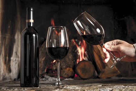 Wine by the fireplace, glasses of wine の写真素材