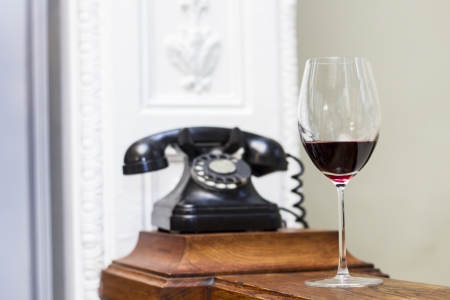 Glass os wine and old vintage clock on the background の写真素材