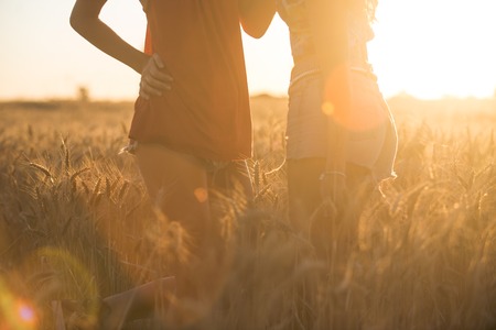 Sexy young girls playing in the fields touching the grain with their hands and hugging.の写真素材