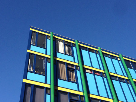 1970s style building rooftop corner against blue sky