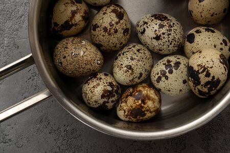 Quail eggs in a metal pan with a handle. Close-up view from aboveの写真素材