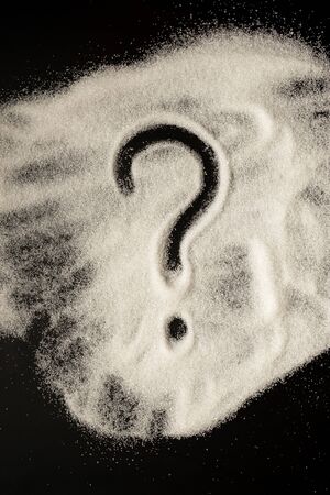 Question mark drawn by sugar on a black tableの写真素材