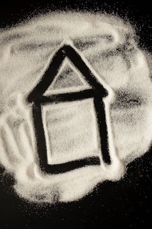 House icon drawn by sugar on a black tableの写真素材