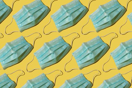 Colorful pattern: medical masks on yellow background flat lay. Close-up, hard light.の写真素材