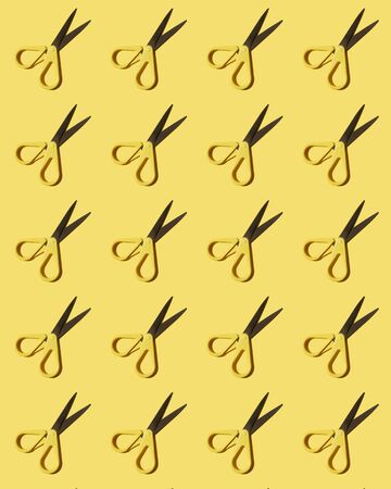 Colorful pattern: stationery scissors on yellow background flat lay. Vertical photo.の写真素材