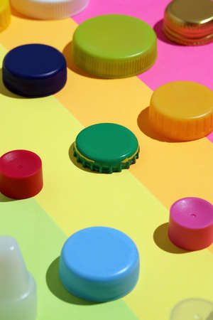 Different multi-colored bottle and jar caps, metal and plastic caps on rainbow surfaceの写真素材