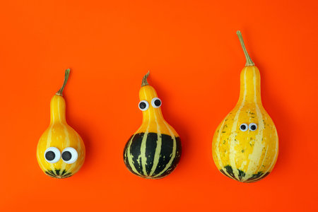 Three pumpkins of different sizes with toy eyes