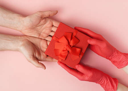 Woman giving a gift in a red cardboard box to a manの写真素材