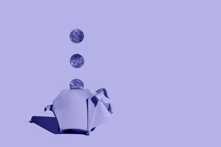 Very peri origami piggy bank and three one cent coins.の写真素材