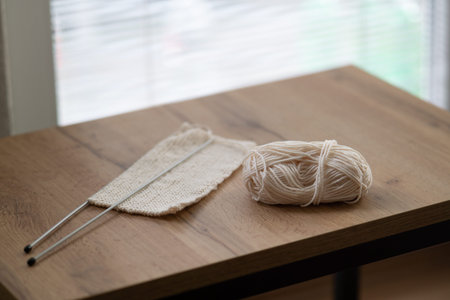 Ball of wool and a scarf in the process of making. Ball of wool, a scarf and knitting needles on a...