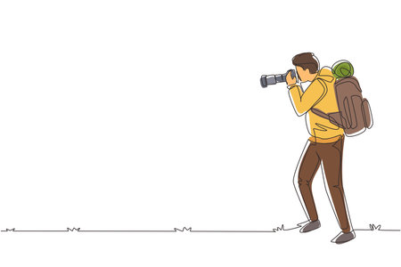 Single one line drawing young male photographer standing taking photo using camera, tourist with backpack. Photographer with his telephoto lens. Continuous line draw design graphic vector illustrationのイラスト素材
