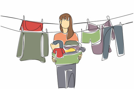 Single continuous line drawing a woman holding a basket filled with piles of clothes. Lift clothes that are dry and clean. Housework. National Hanging Out Day. One line design vector illustrationのイラスト素材