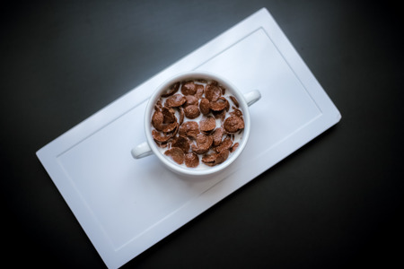 Chocolate Cereal in White Ceramic Bowl with Black Backgroundの写真素材