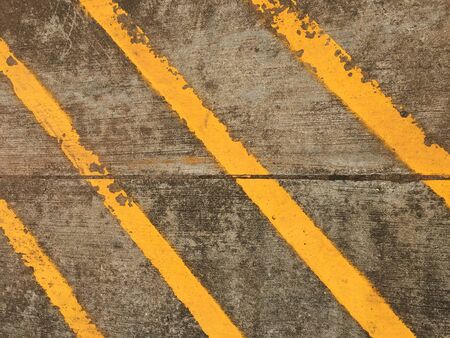 cement wall texture with yellow stripeの写真素材
