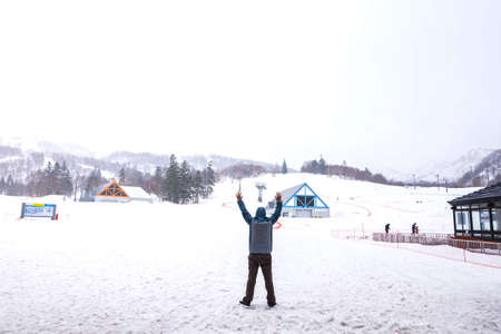 The man is standing and putting the hand into the air on the snow at Kiroro resort Sapporo,Hokkaidoのeditorial素材