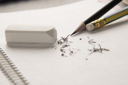 white eraser and pencil on notebook