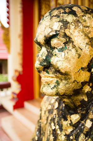 Statue of monk cover with gold leaves in Buddha temple Bangkok, Thailandの写真素材